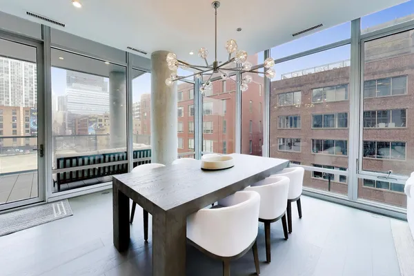 a view of a dining room with furniture large windows and wooden floor