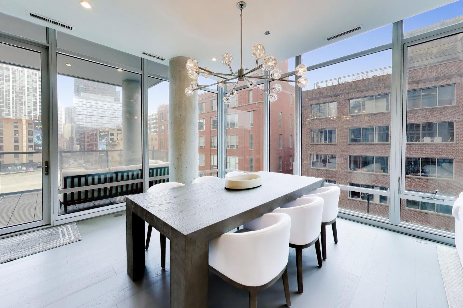 360 West Erie Street, Unit 5D Chicago, IL 60654 - Photo 9 of 41 a view of a dining room with furniture large windows and wooden floor