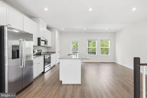 a kitchen with a refrigerator and a stove top oven