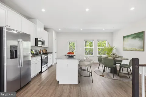 a kitchen with a table chairs refrigerator and cabinets