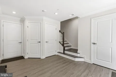a view of an empty room with wooden floor and closet area