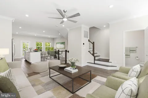 a living room with furniture and a view of kitchen