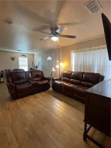 a living room with furniture a large window and a chandelier