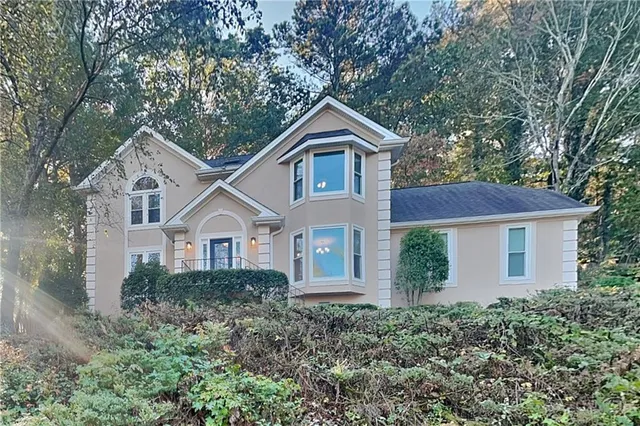 a front view of a house with yard and green space