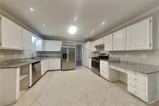 a large kitchen with stainless steel appliances granite countertop a stove sink and cabinets