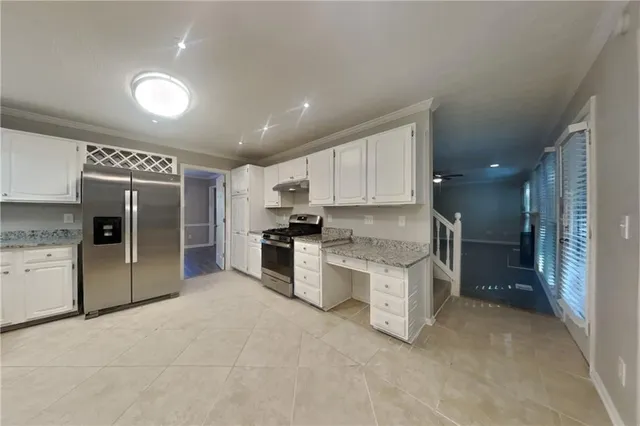 a large kitchen with a large counter top stainless steel appliances and cabinets