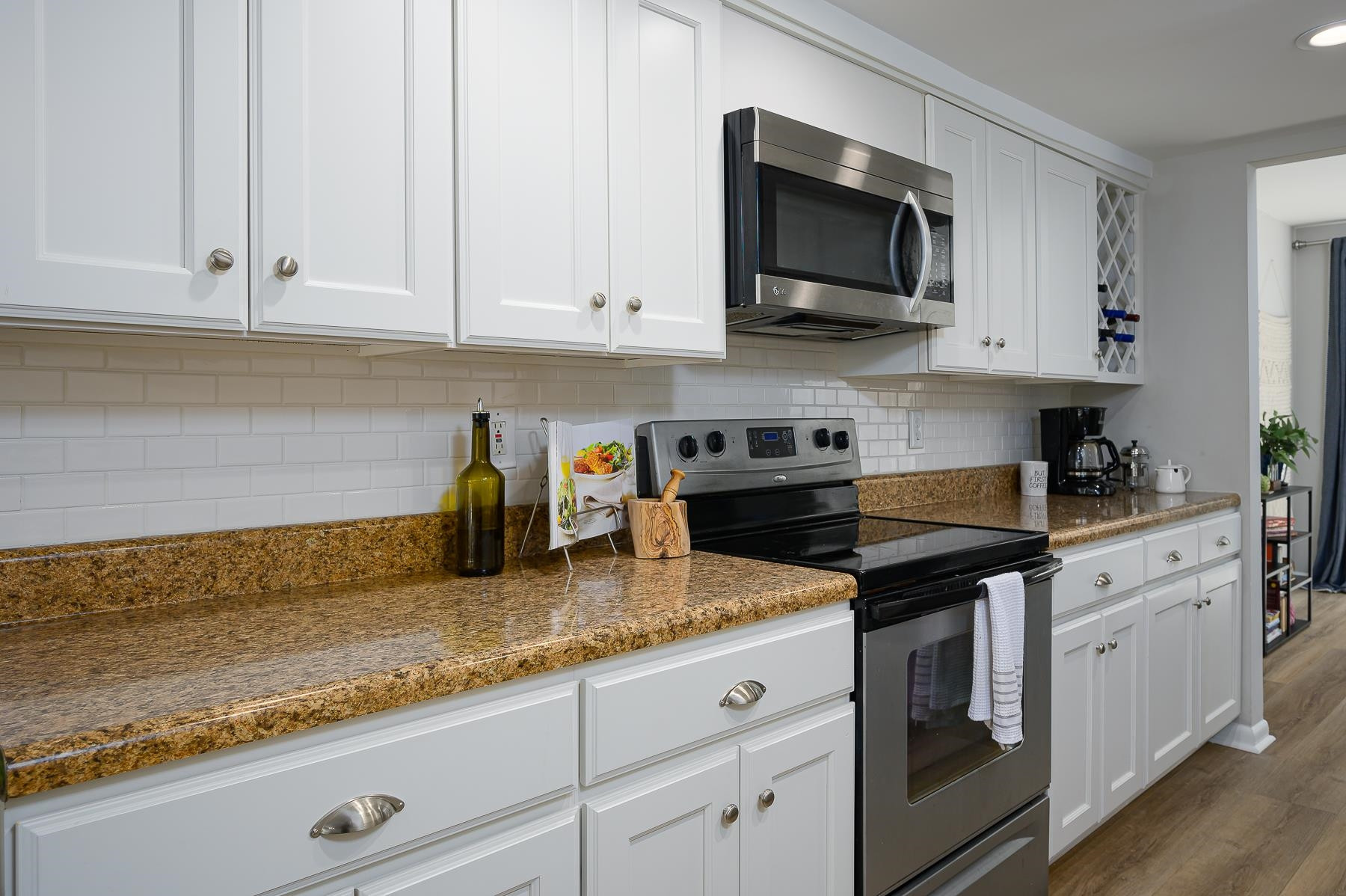 1714 Quail Ridge Road Raleigh, NC 27609 - Photo 8 of 25 a kitchen with granite countertop white cabinets and a stove top oven
