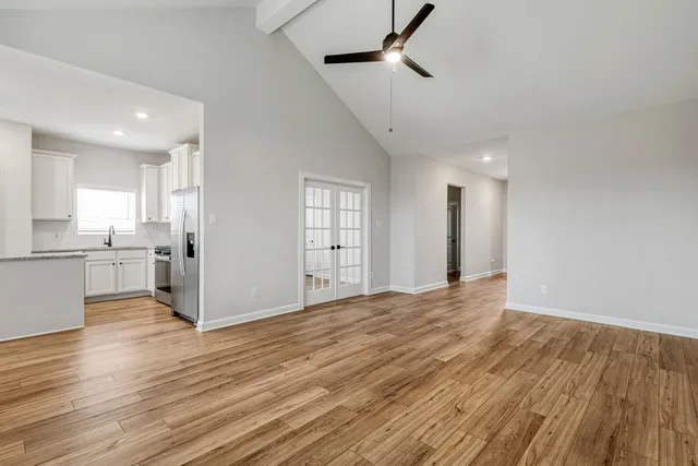 a view of a kitchen with wooden floor and a window