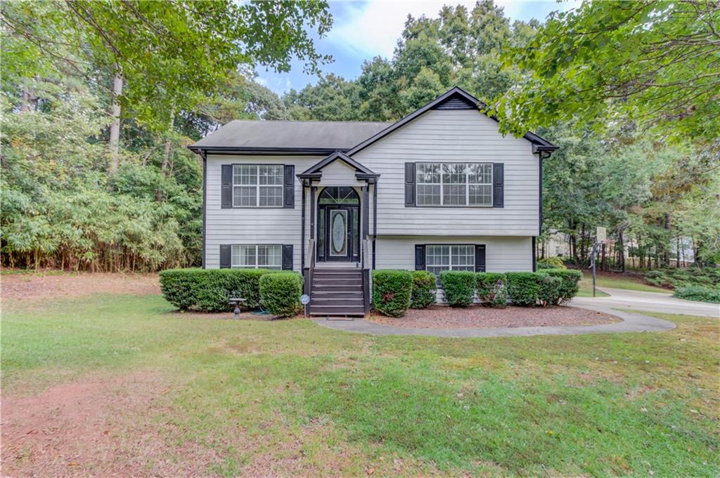 a front view of a house with a yard and potted plants