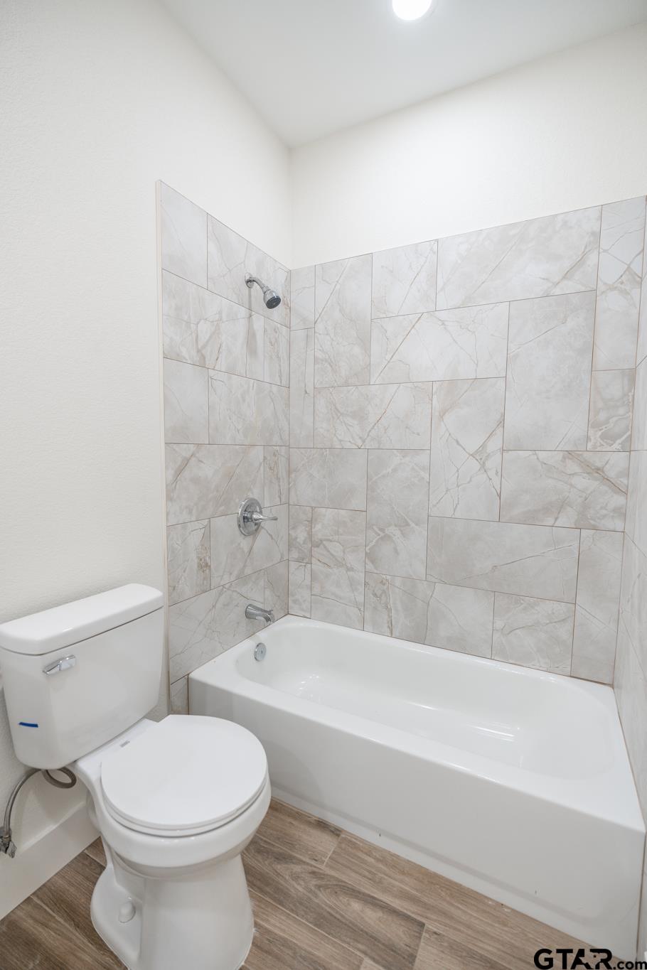 413 Stewart Street Lindale, TX 75771 - Photo 21 of 39 a bathroom with a toilet and a bathtub