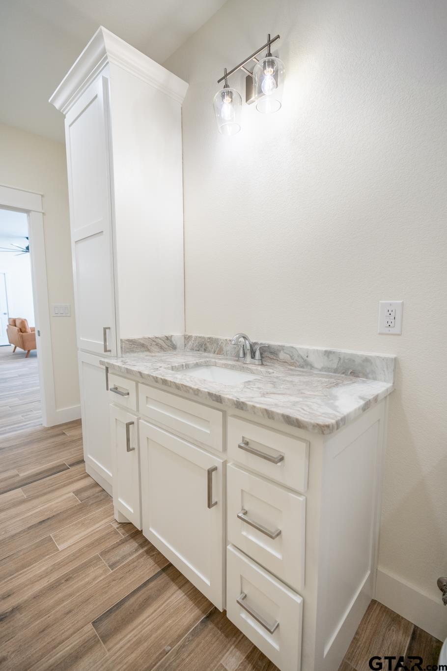 413 Stewart Street Lindale, TX 75771 - Photo 22 of 39 a spacious bathroom with a granite countertop sink and a mirror