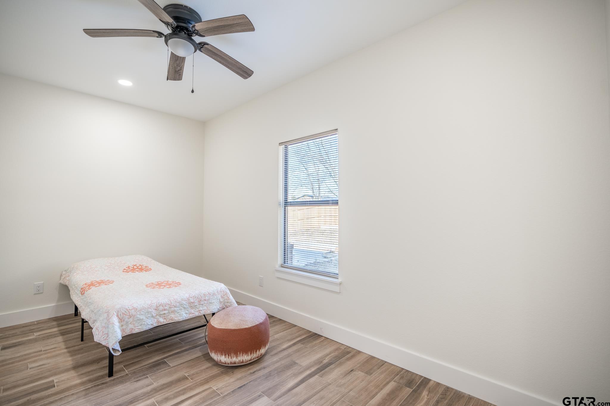 413 Stewart Street Lindale, TX 75771 - Photo 26 of 39 a bedroom with a bed and wooden floor