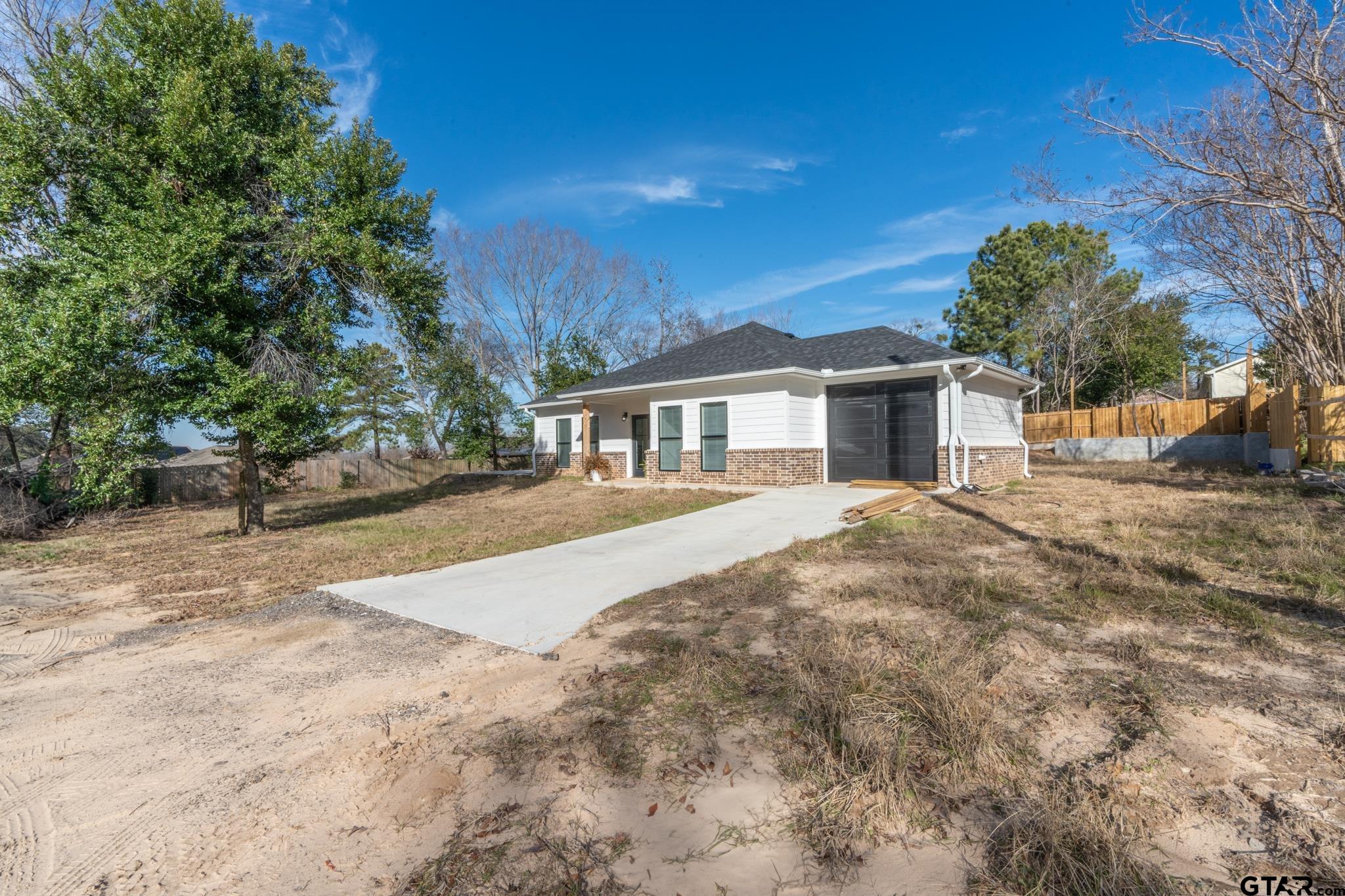 413 Stewart Street Lindale, TX 75771 - Photo 3 of 39 a view of house with yard and trees in the background