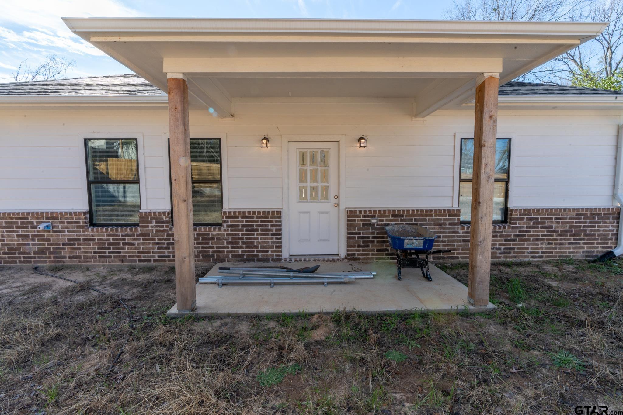 413 Stewart Street Lindale, TX 75771 - Photo 35 of 39 a view of a patio with table and chairs near a barn