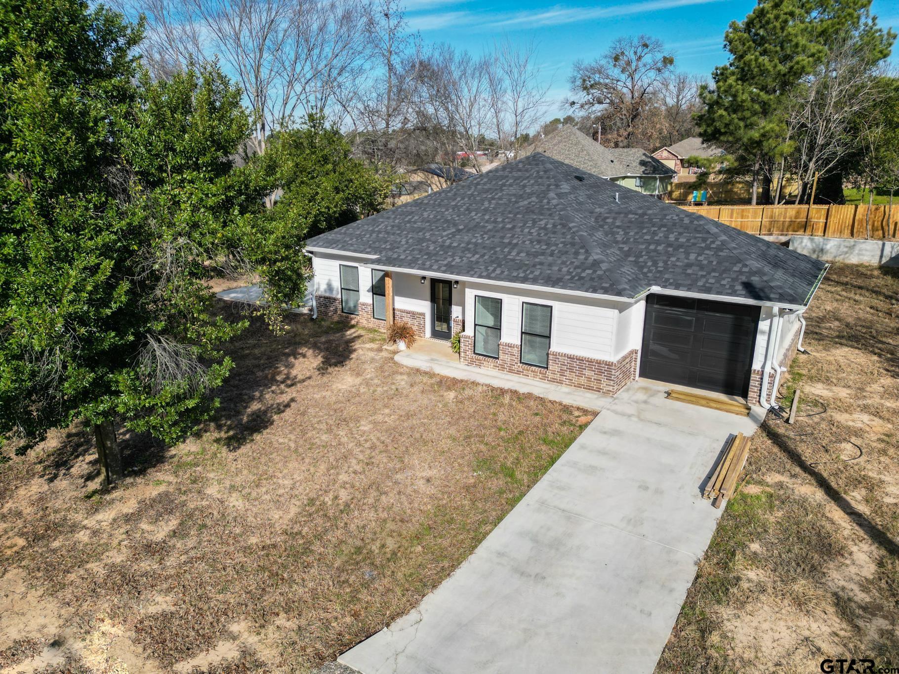 413 Stewart Street Lindale, TX 75771 - Photo 6 of 39 a house view with a backyard space