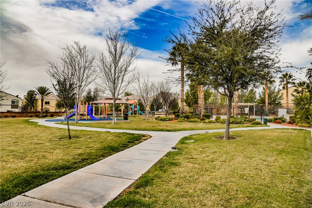 6320 Snap Ridge Street, Unit 201 North Las Vegas, NV 89081 - Photo 42 of 56 A vibrant green lawn and curving pathways lead to a community playground and fenced pool area.