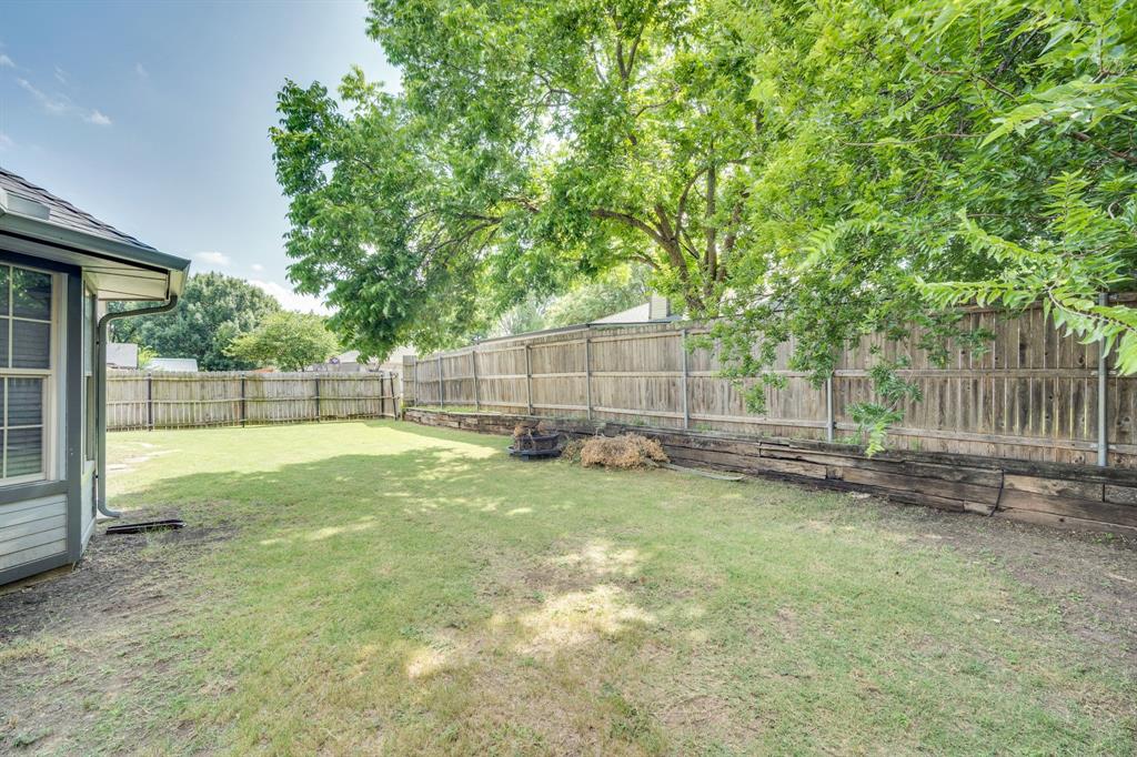 1001 Short Line Boulevard Midlothian, TX 76065 - Photo 14 of 26 Spacious backyard with a wood privacy fence, mature trees, and a manicured lawn