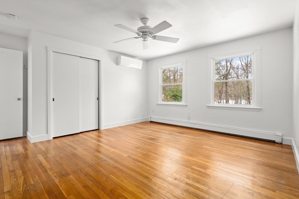 28 Meyer Road Hamilton, MA 01982 - Photo 11 of 22 an empty room with wooden floor chandelier fan and windows
