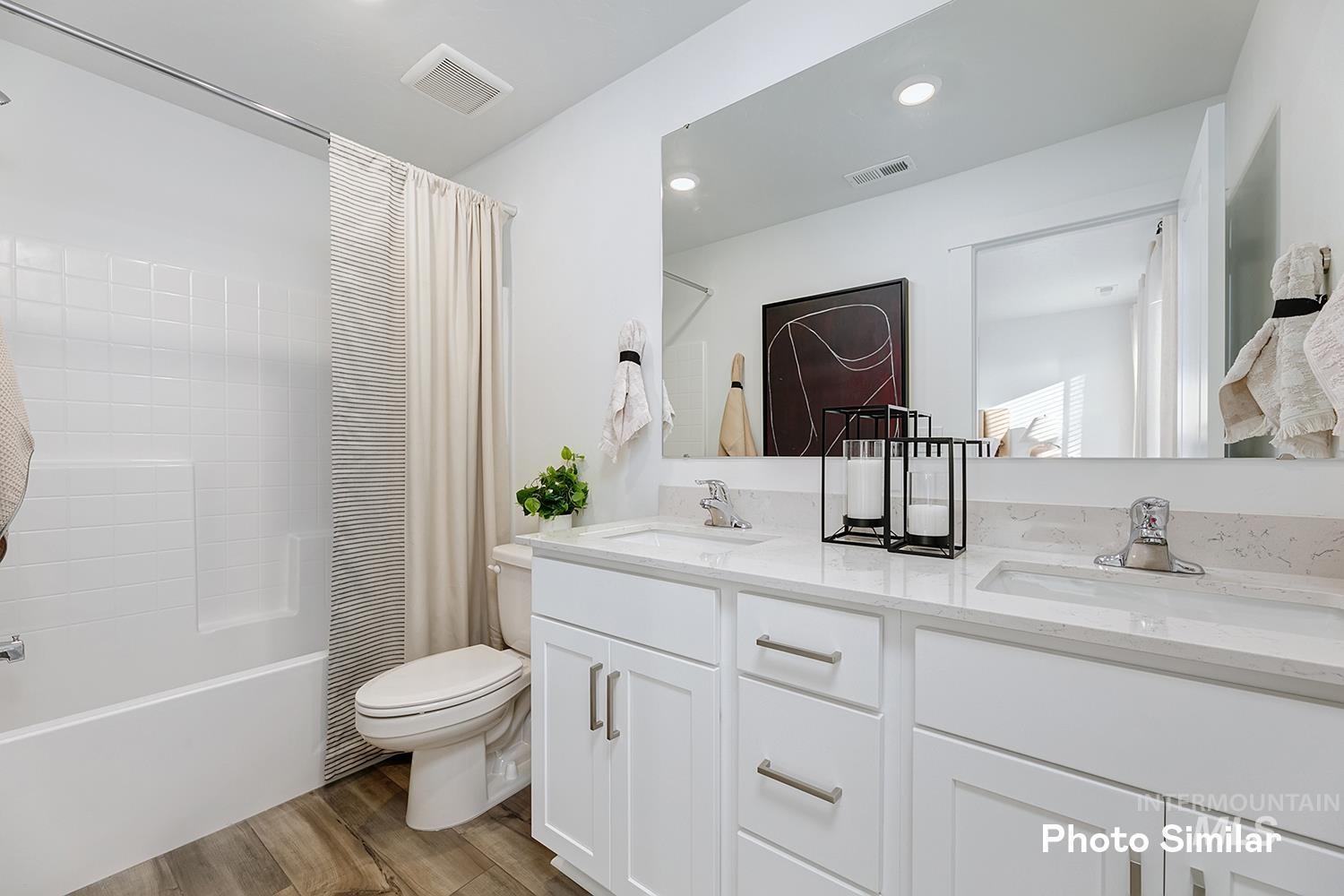 3045 North Kankakee Way Kuna, ID 83634 - Photo 14 of 19 Full bath with dark wood-type flooring, double vanity, shower / bath combo with shower curtain, and recessed lighting