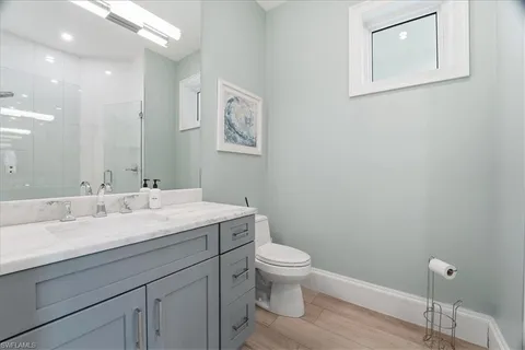 a bathroom with a granite countertop toilet sink and mirror