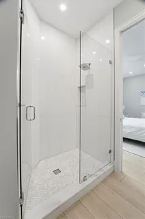 a bathroom with a glass shower door and a sink