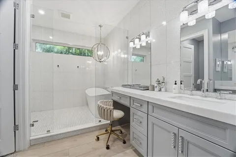 a bathroom with a sink mirror and a shower