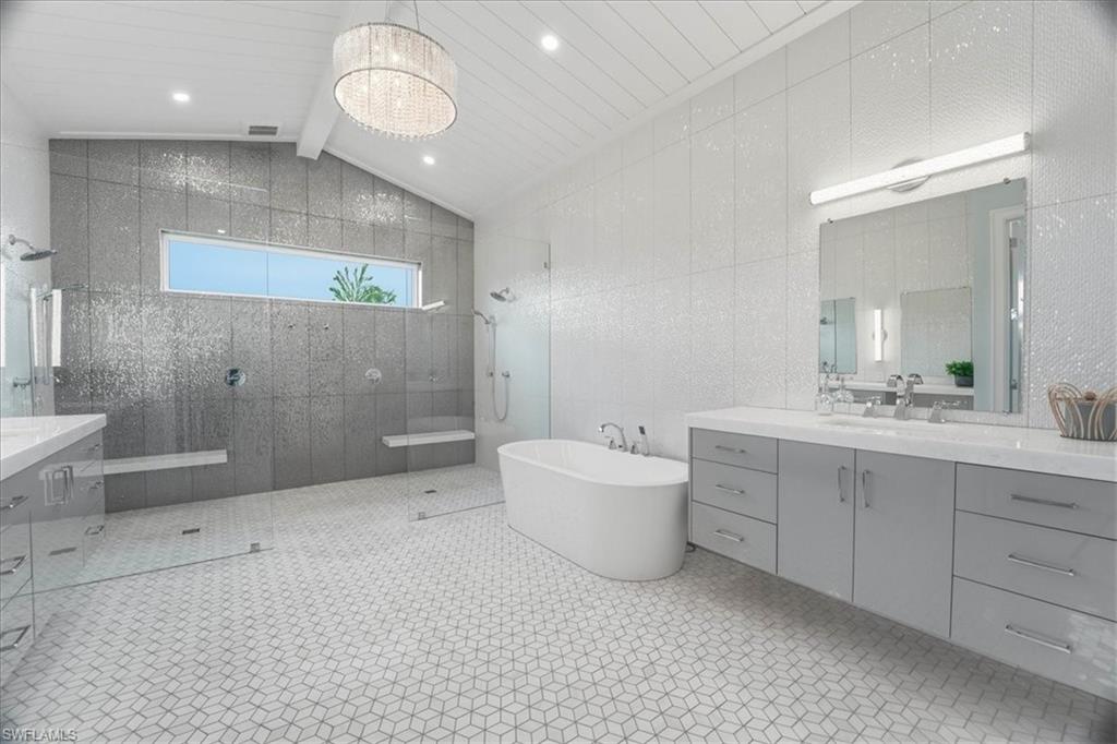 5130 Alpha Court Naples, FL 34105 - Photo 41 of 49 a spacious bathroom with a bathtub sink mirror double vanity and a bathtub