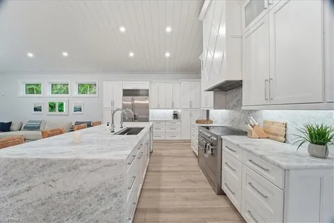 a large kitchen with kitchen island a sink stainless steel appliances and cabinets