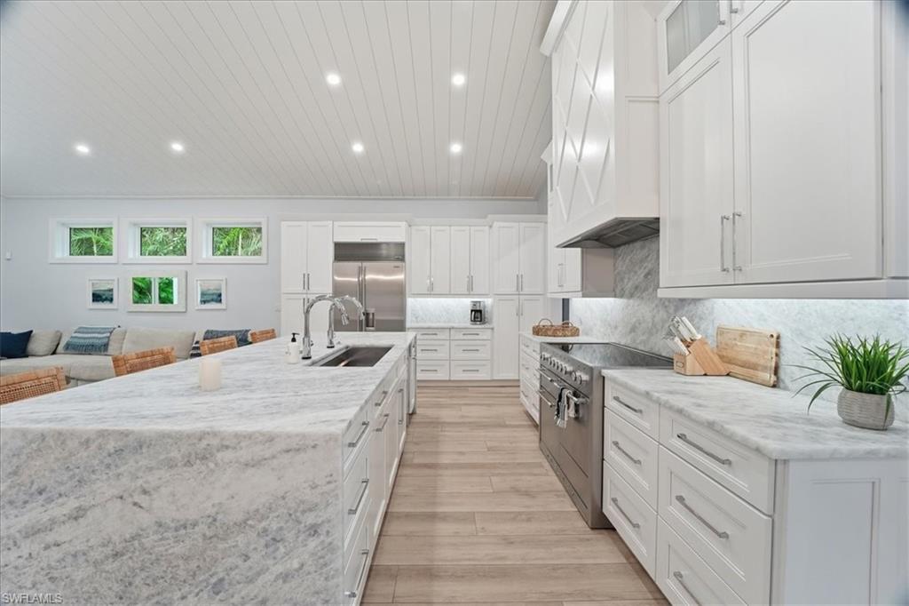 5130 Alpha Court Naples, FL 34105 - Photo 8 of 49 a large kitchen with kitchen island a sink stainless steel appliances and cabinets