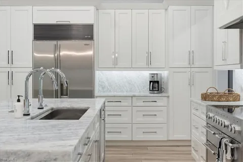 a kitchen with white cabinets and a sink