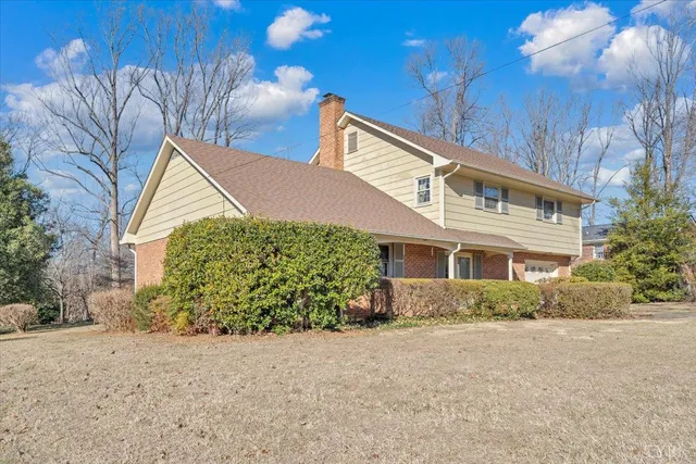 a view of a house with a yard and potted plants
