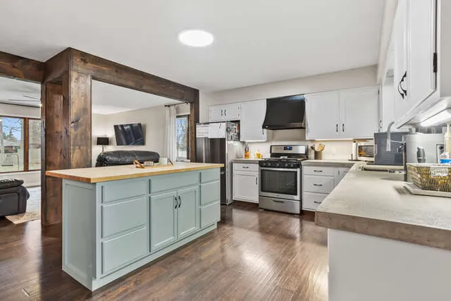 a kitchen with granite countertop a refrigerator stove top oven and sink