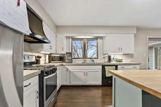 a kitchen with stainless steel appliances a sink stove and cabinets