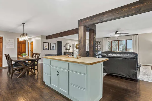 a kitchen with kitchen island granite countertop wooden floors and white cabinets
