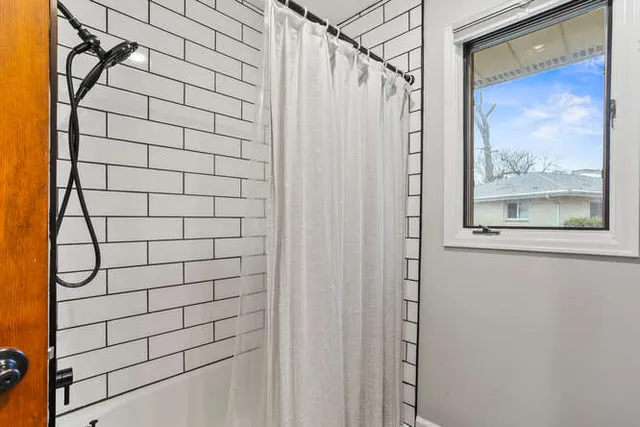 a bedroom with a bed and a large window