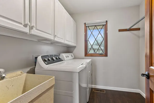 a view of a house with a yard and large tree