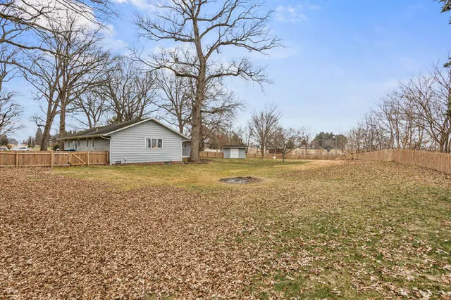 a view of backyard of house with trees