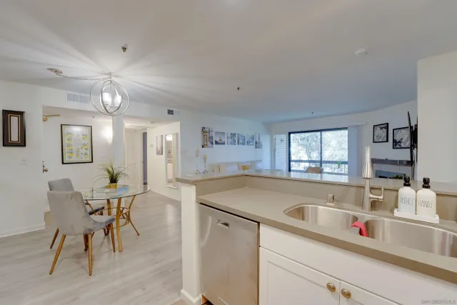 a kitchen with a table chairs and white cabinets