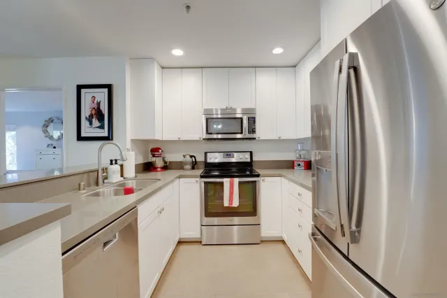 a kitchen with stainless steel appliances granite countertop a refrigerator and a sink