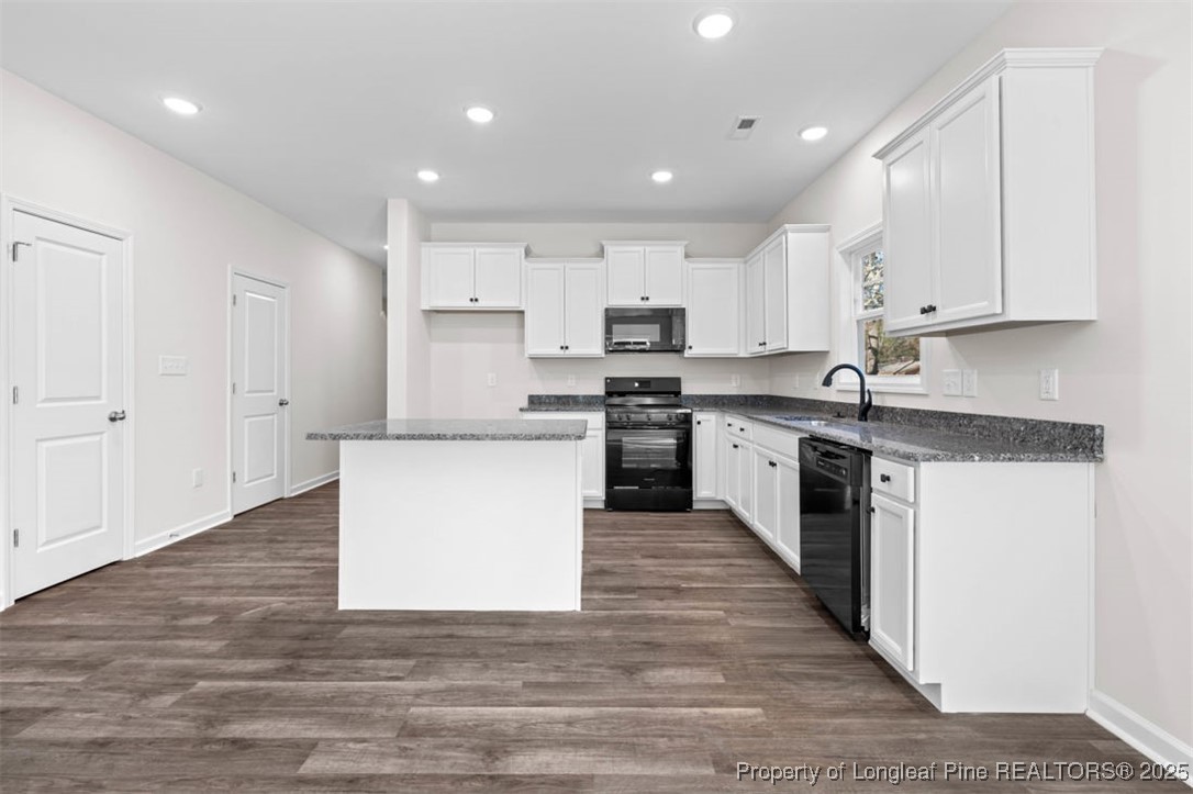 229 Ruritan Drive Fayetteville, NC 28314 - Photo 8 of 16 a large kitchen with stainless steel appliances granite countertop a stove top oven a sink and white cabinets