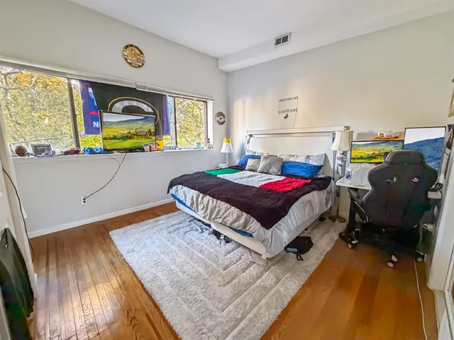 a bedroom with a bed and wooden floor