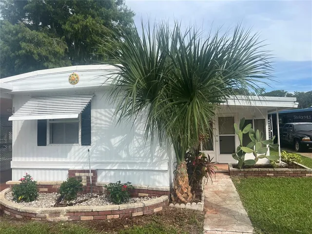 a view of a house with backyard and sitting area