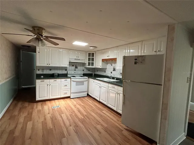 an empty room with a window and ceiling fan