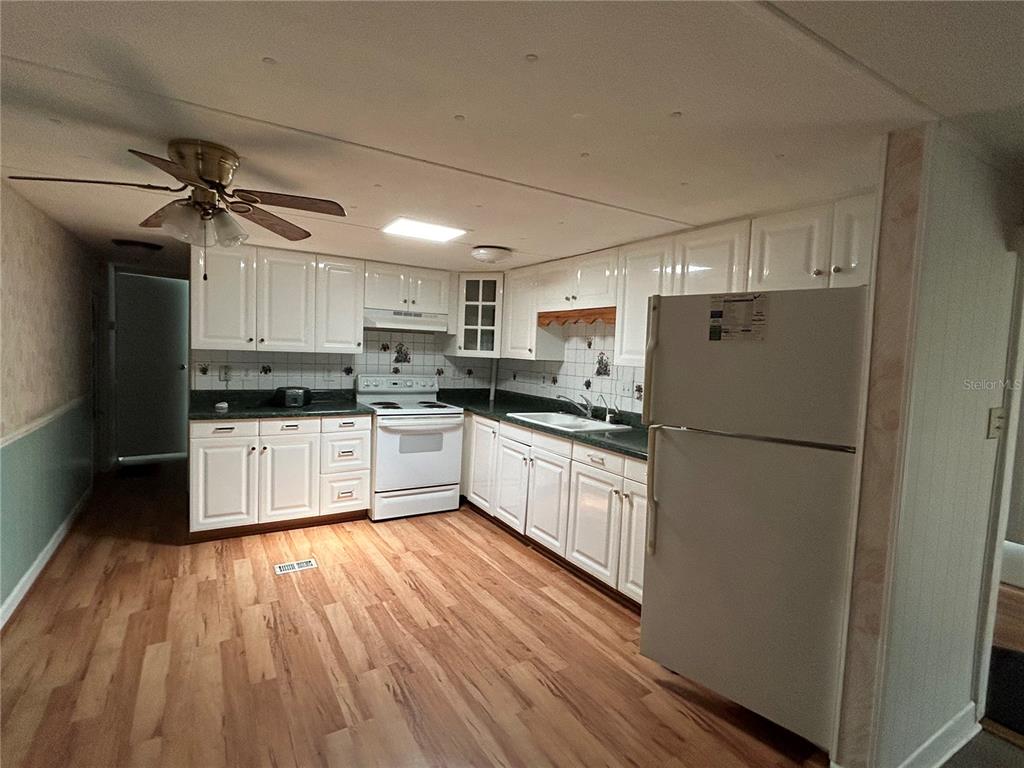 240 Rue De Fontaine Tavares, FL 32778 - Photo 21 of 43 a kitchen with a refrigerator a sink and cabinets