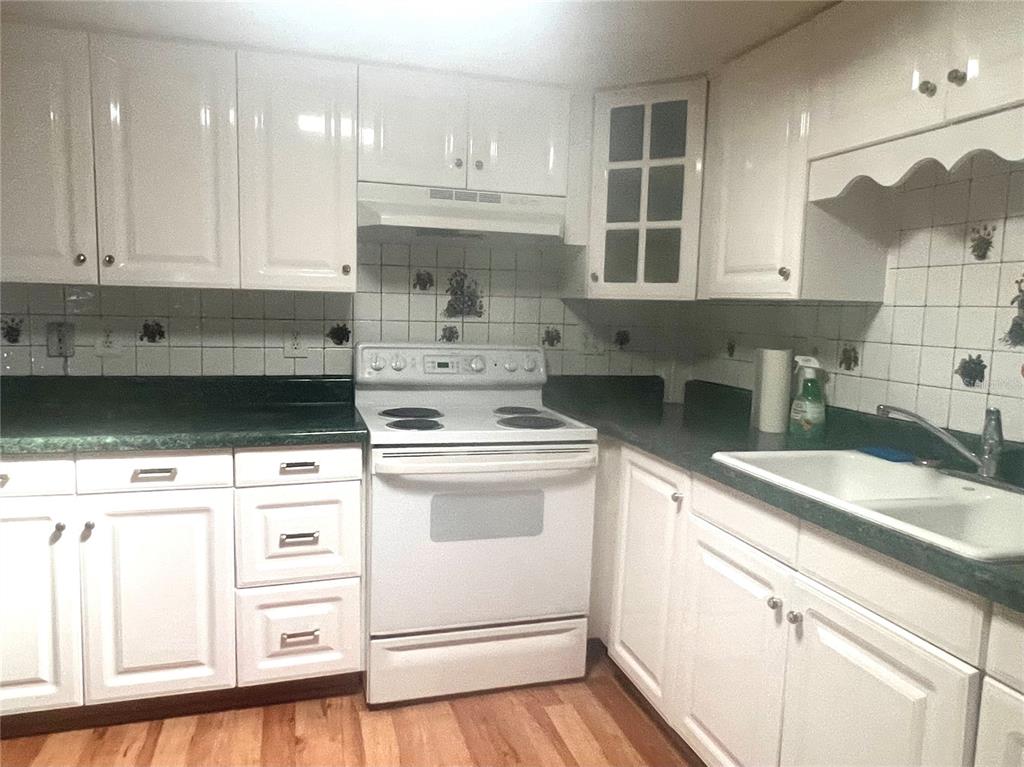 240 Rue De Fontaine Tavares, FL 32778 - Photo 23 of 43 a kitchen with kitchen island white cabinets and white appliances