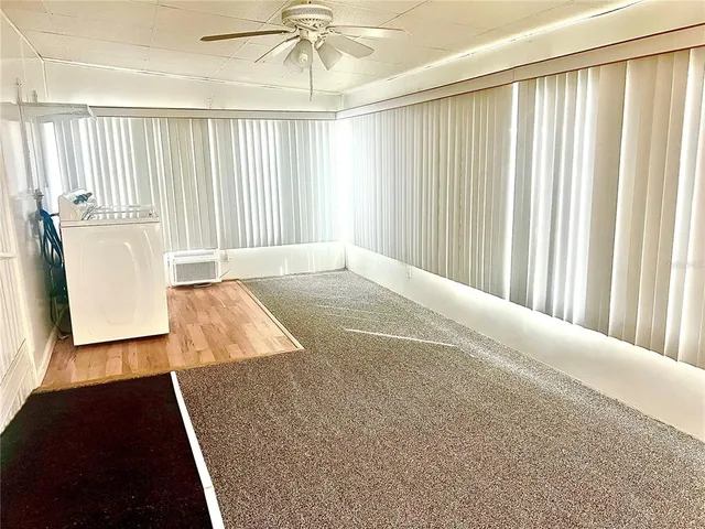 an empty room with windows and cabinet