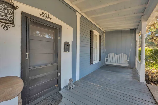 a view of a hallway with wooden floor and a bathroom