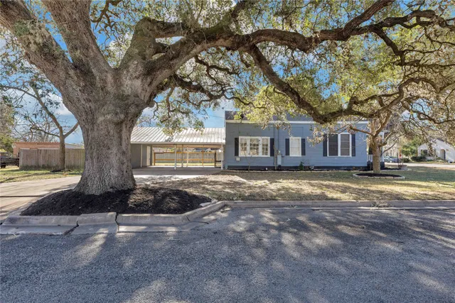a front view of a house with a yard and trees