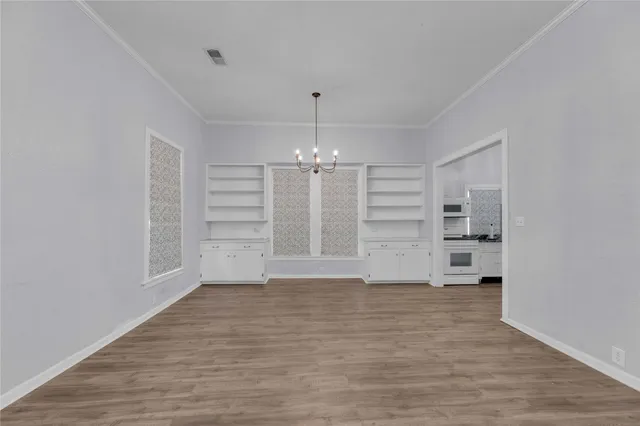 wooden floor in an empty room with a kitchen