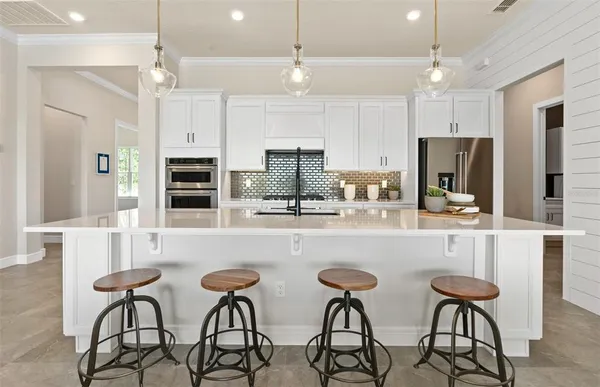 a kitchen with white cabinets and appliances